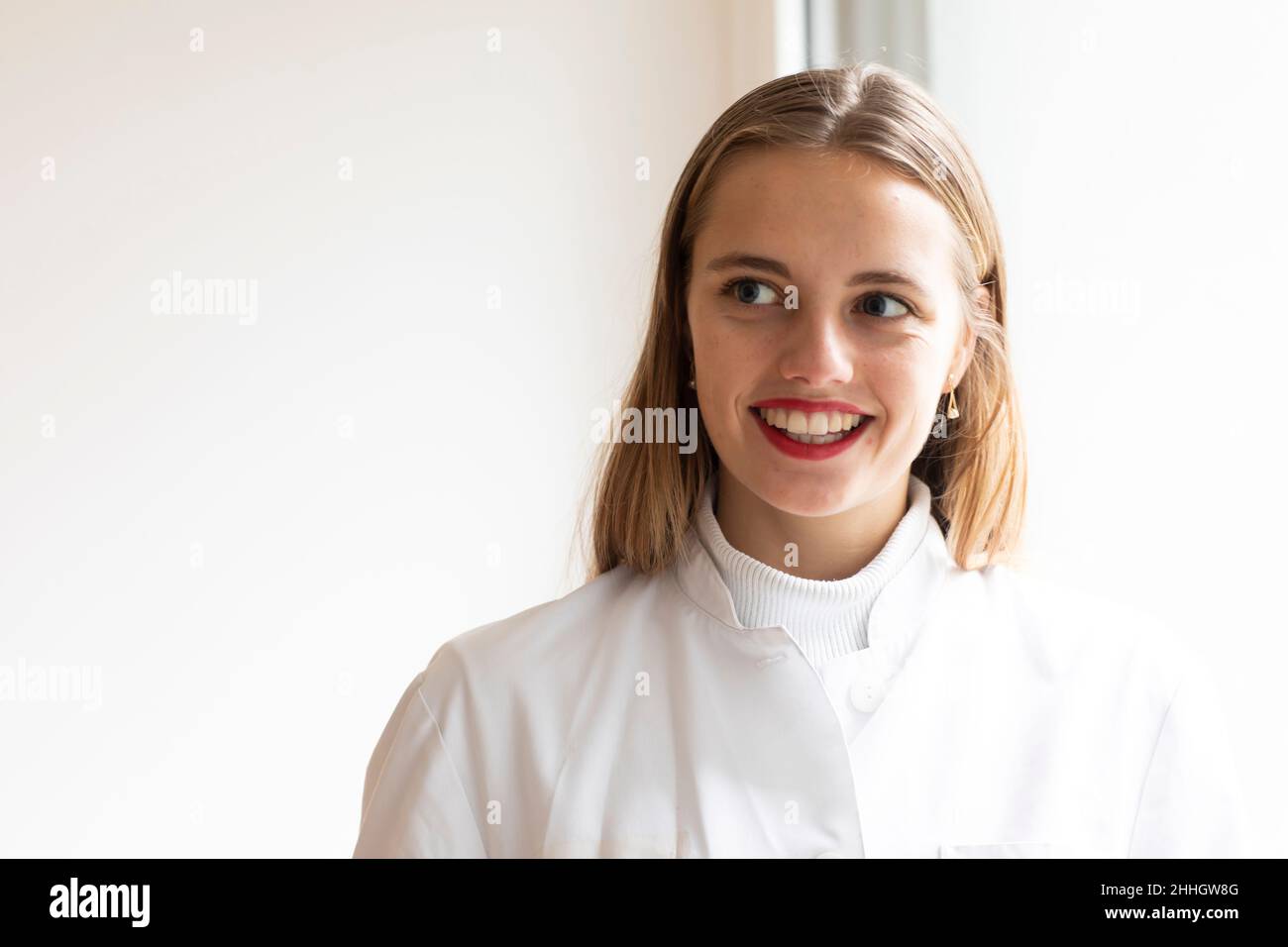 Portrait of smiling young woman in lab coat Stock Photo