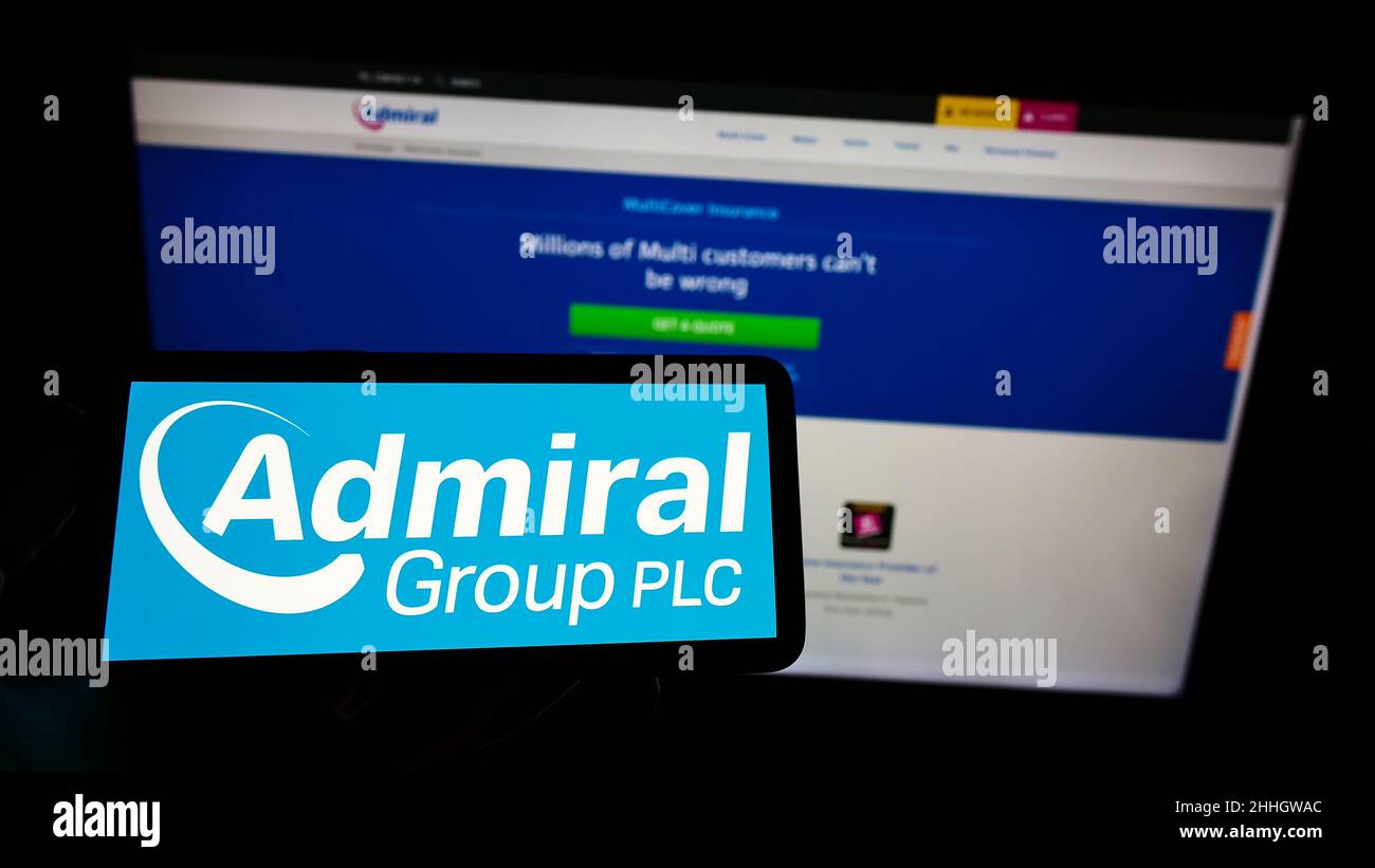 Person holding cellphone with logo of British insurance company Admiral Group plc on screen in front of business webpage. Focus on phone display. Stock Photo