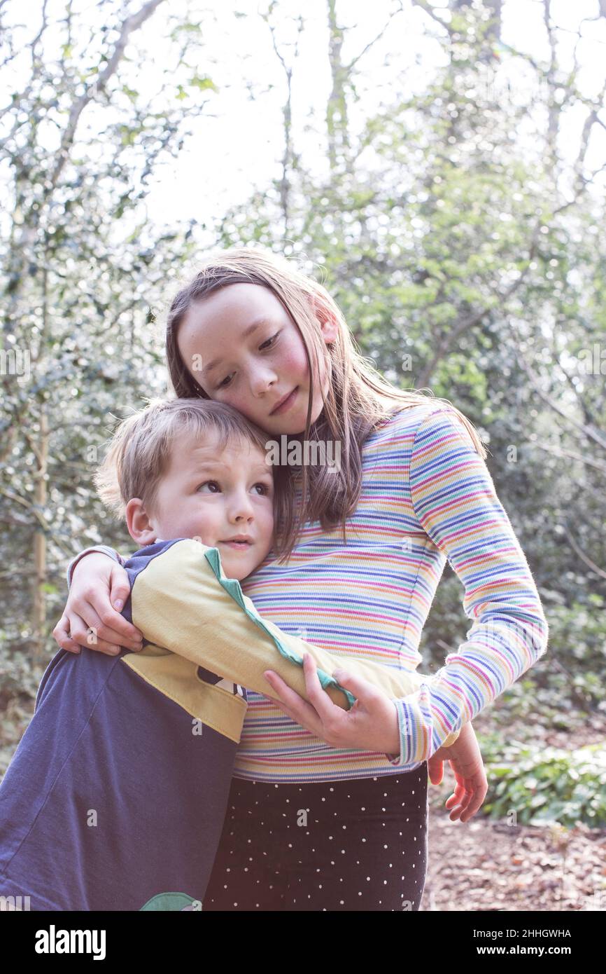 Brother and sister hugging in forest Stock Photo - Alamy