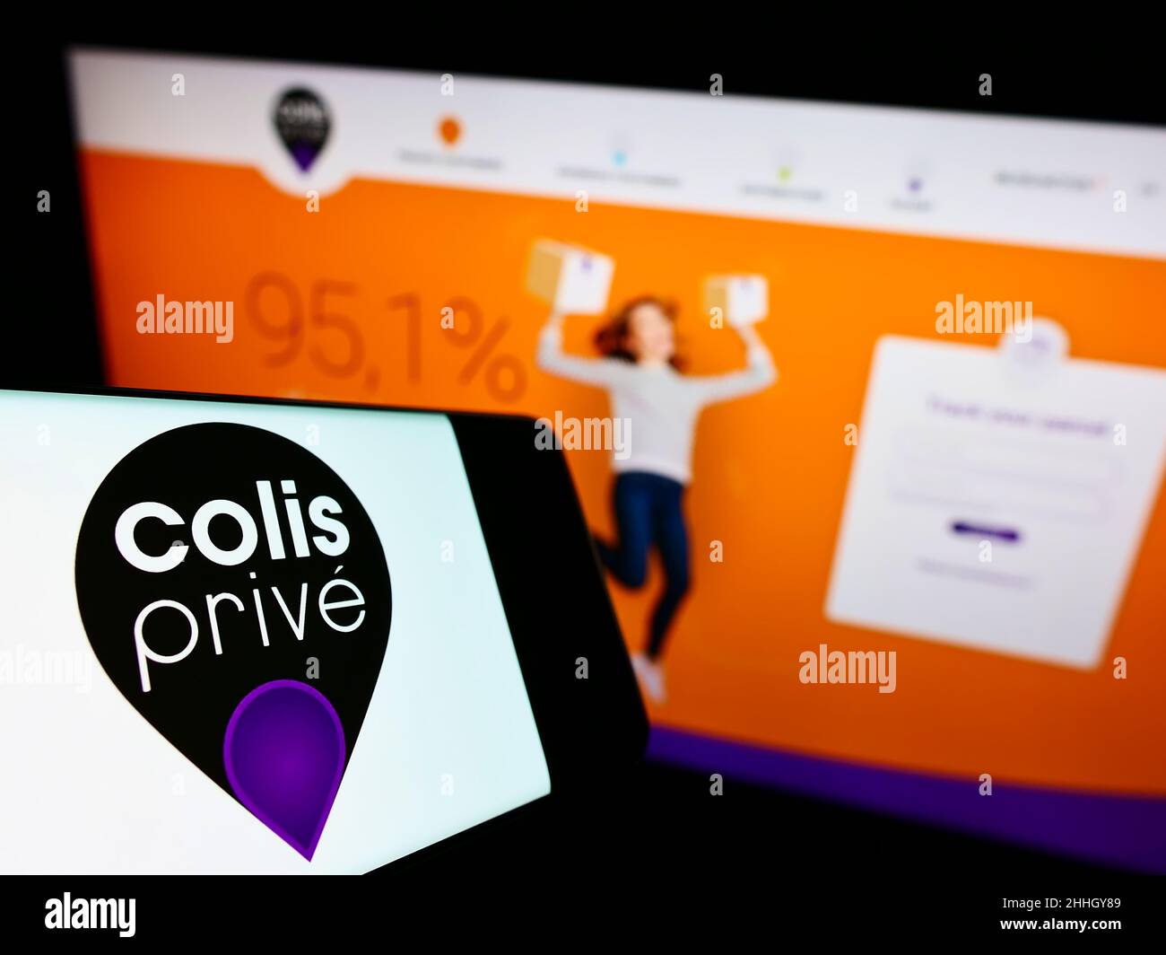 Mobile phone with logo of French logistics company Colis Prive SAS on screen in front of