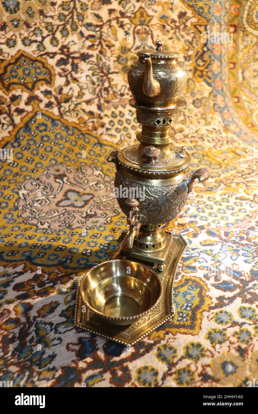 small charcoal heated tea samovar with cup, Kashmir carpet as background Stock Photo