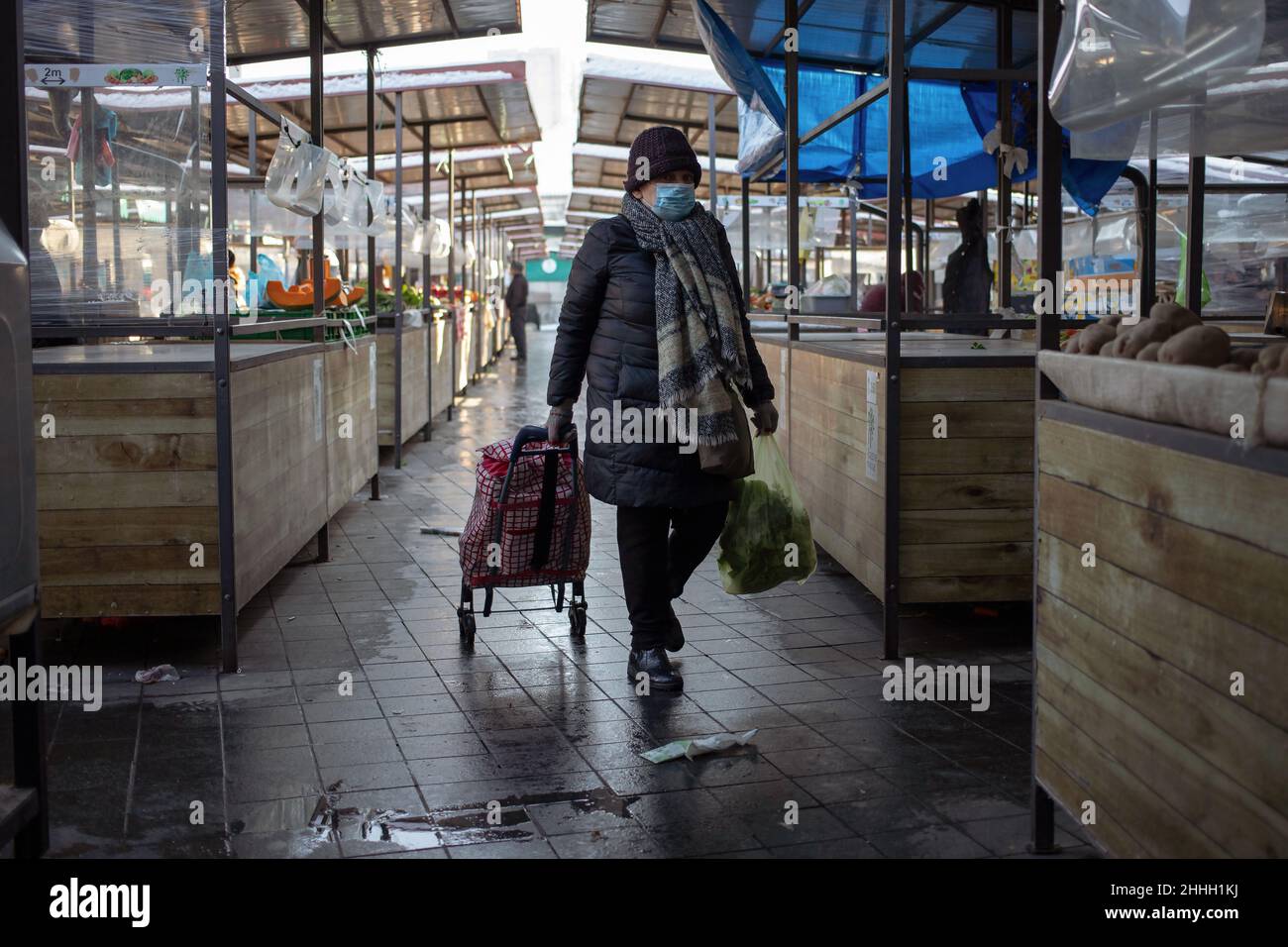 Belgrade, Serbia, Jan 23, 2022: Woman with shopping trolley wearing a face mask walking around the marketplace in Zemun Stock Photo