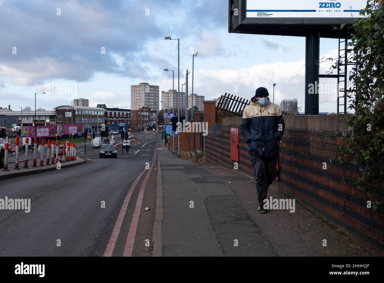 Man wearing a face mask along the A34 towards housing estate tower