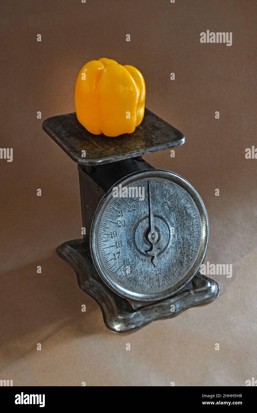 Portrait of a vintage kitchen scale weighing brightly colored bell peppers. Stock Photo