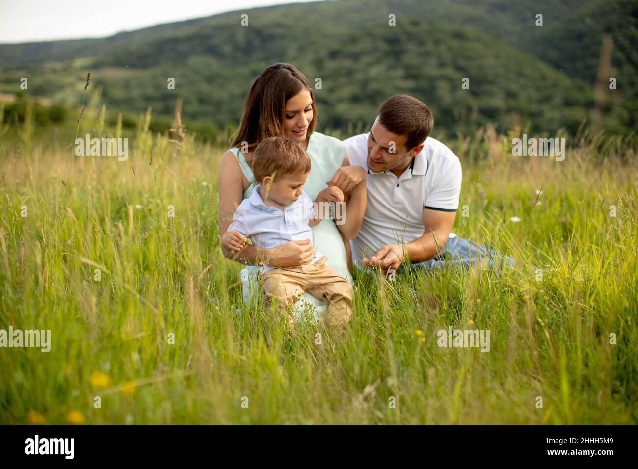 Young family having fun outdoors in the summer field Stock Photo