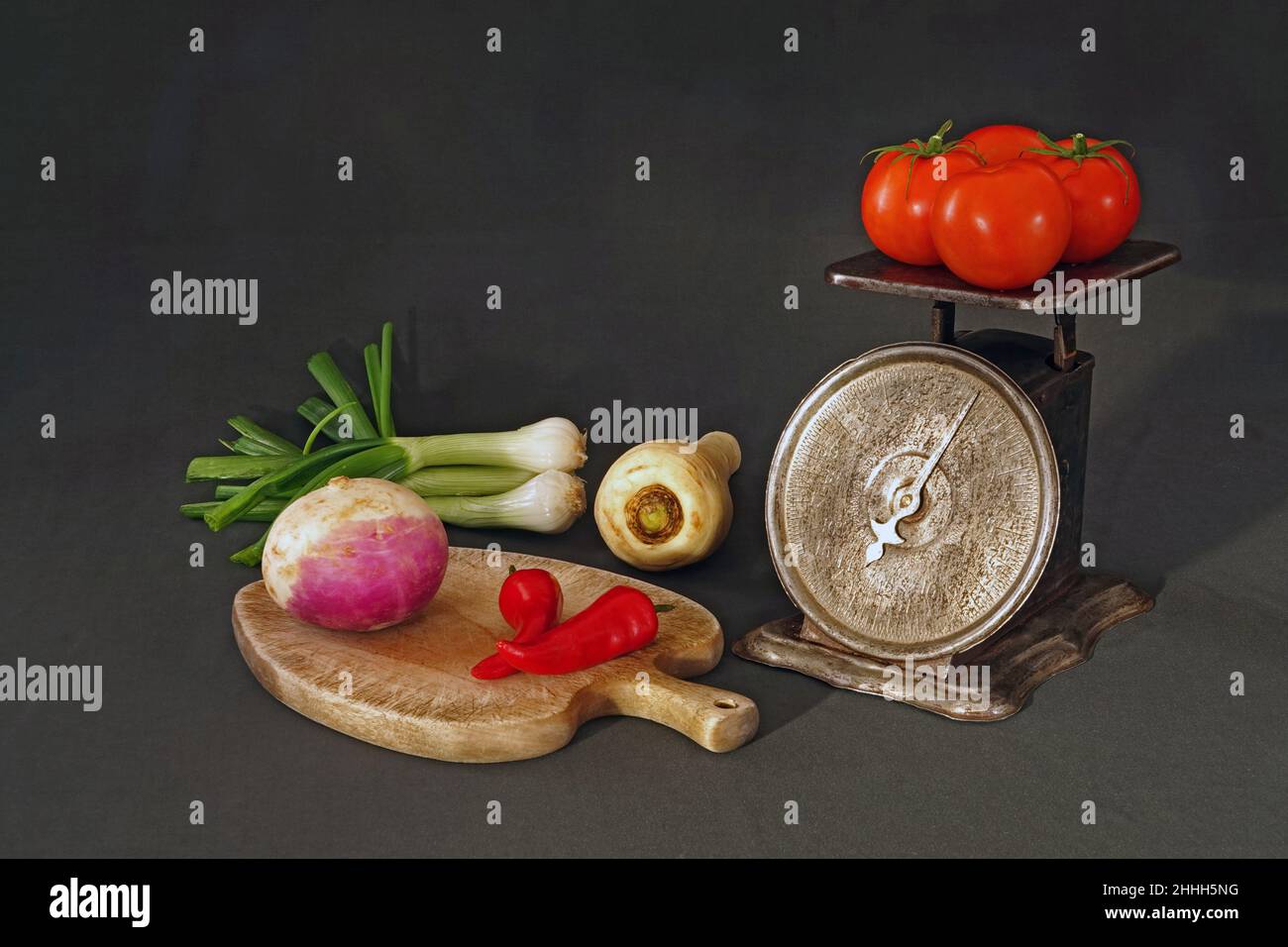 Still life of organic vegetables for a stew, and a vintage kitchen scale. Stock Photo