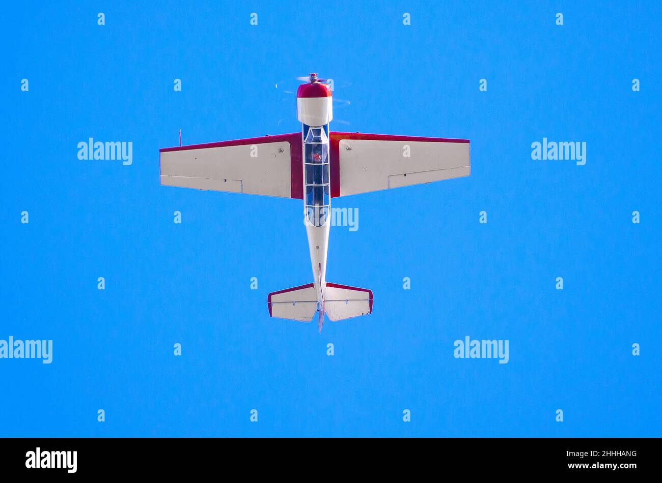 Airplane flys upside down in the blue sky Stock Photo - Alamy