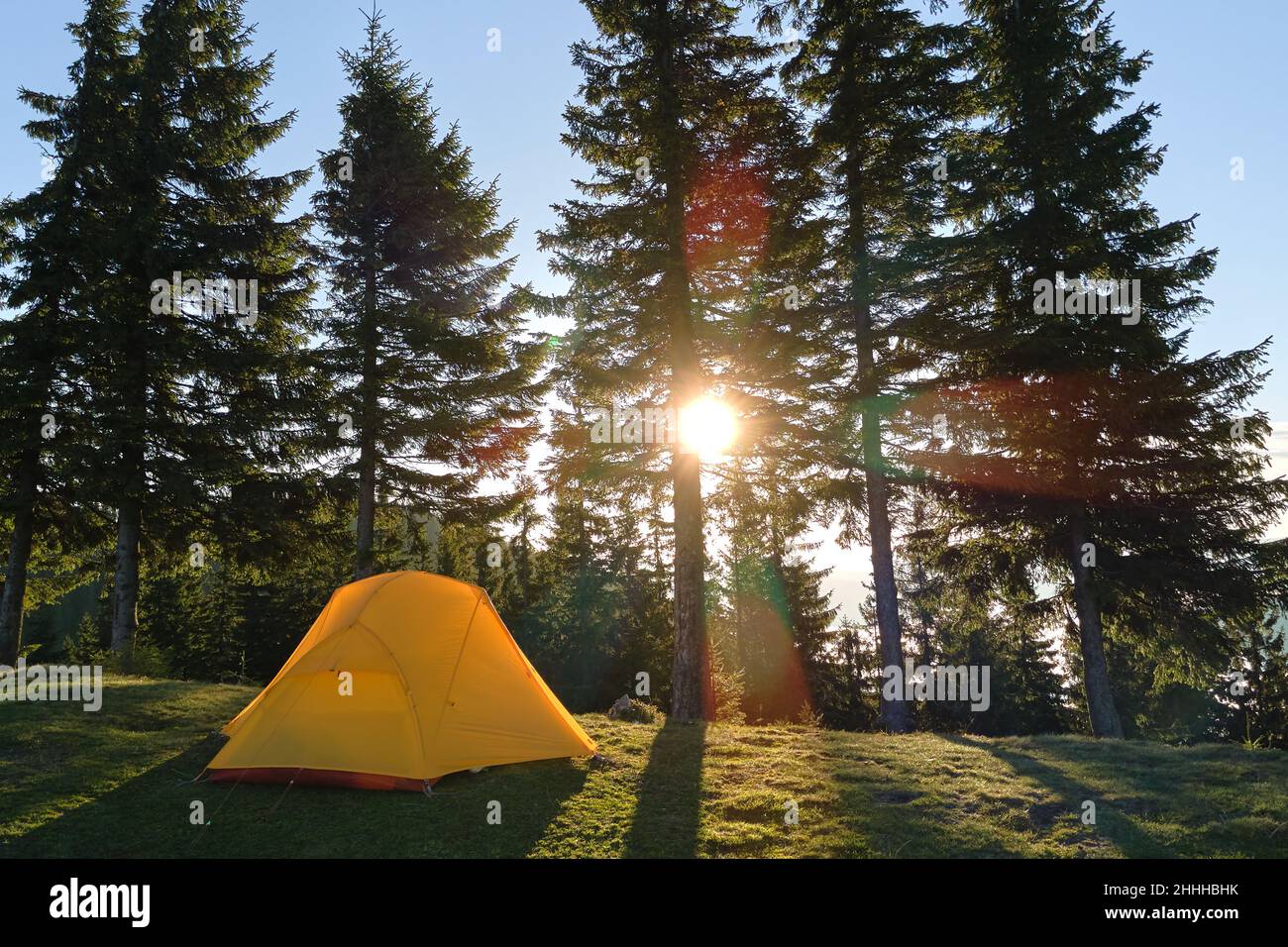 Tourist camping tent on mountain campsite at bright sunny evening ...