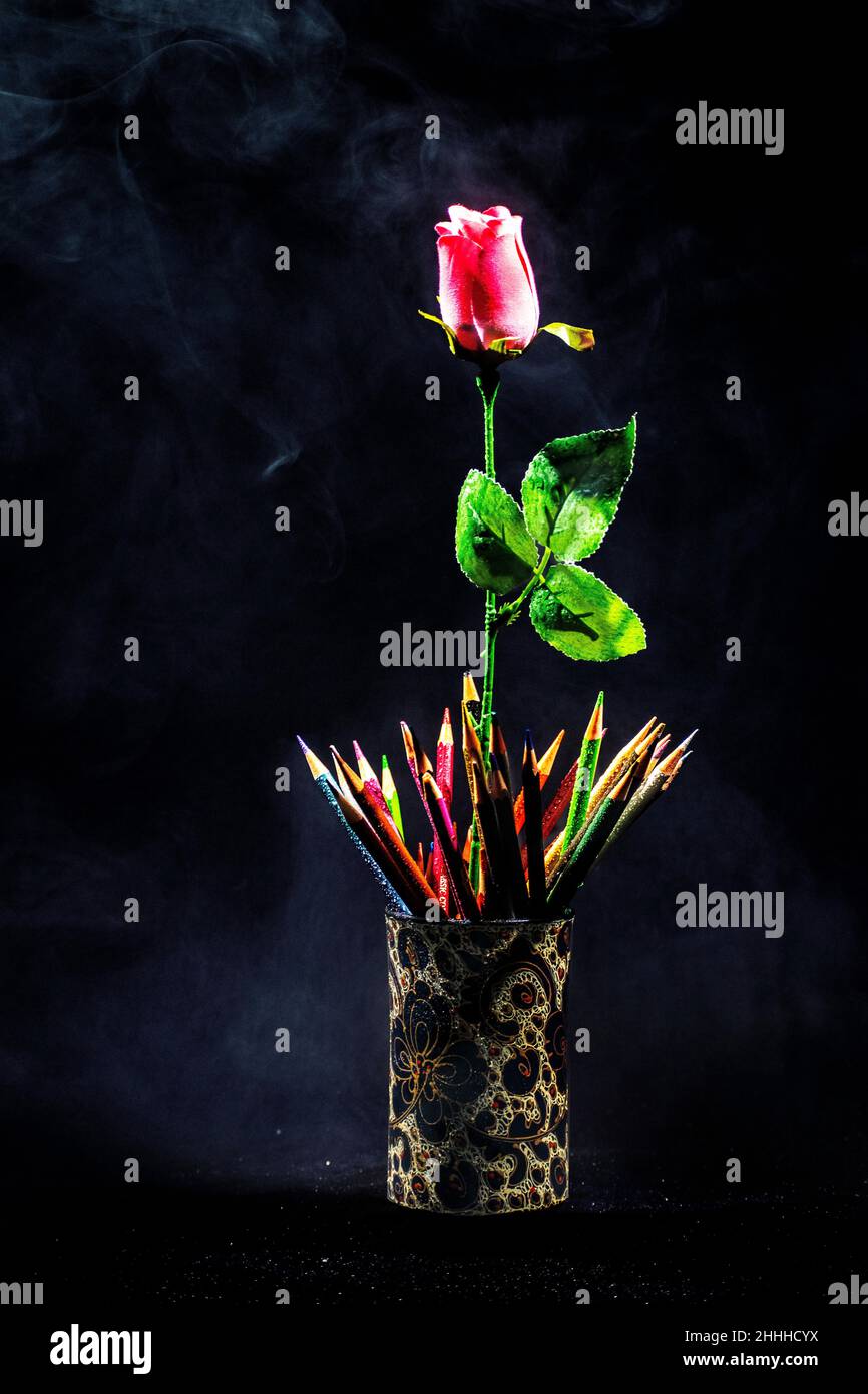 This photo created by using actual smoke, a pink rose, and some colorful pencil crayons giving the image a mystical appearance, ideal for a poster Stock Photo