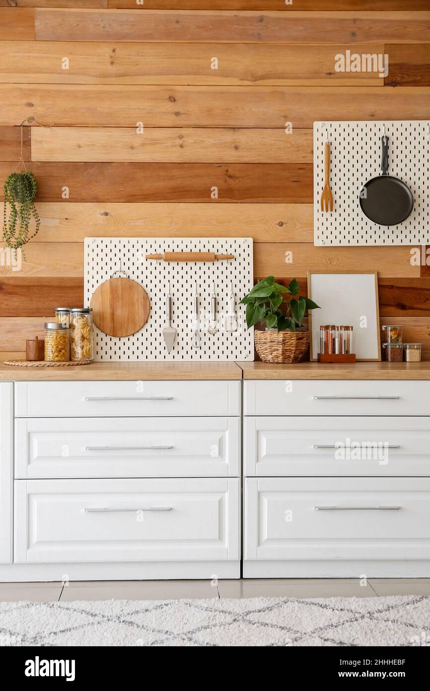 Interior of modern kitchen with white counters, peg boards and wooden ...