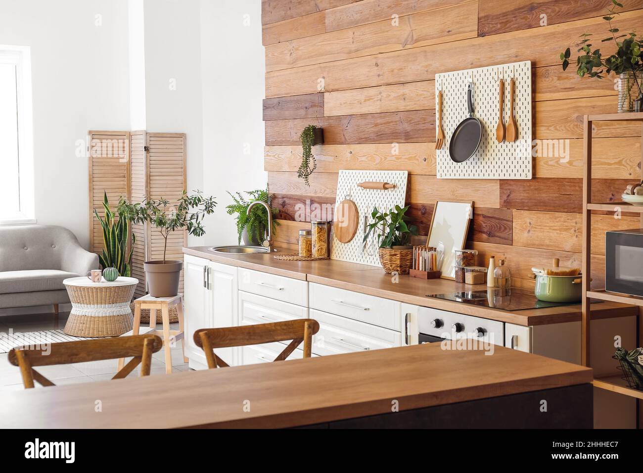 Interior of modern kitchen with white counters, peg boards and wooden ...
