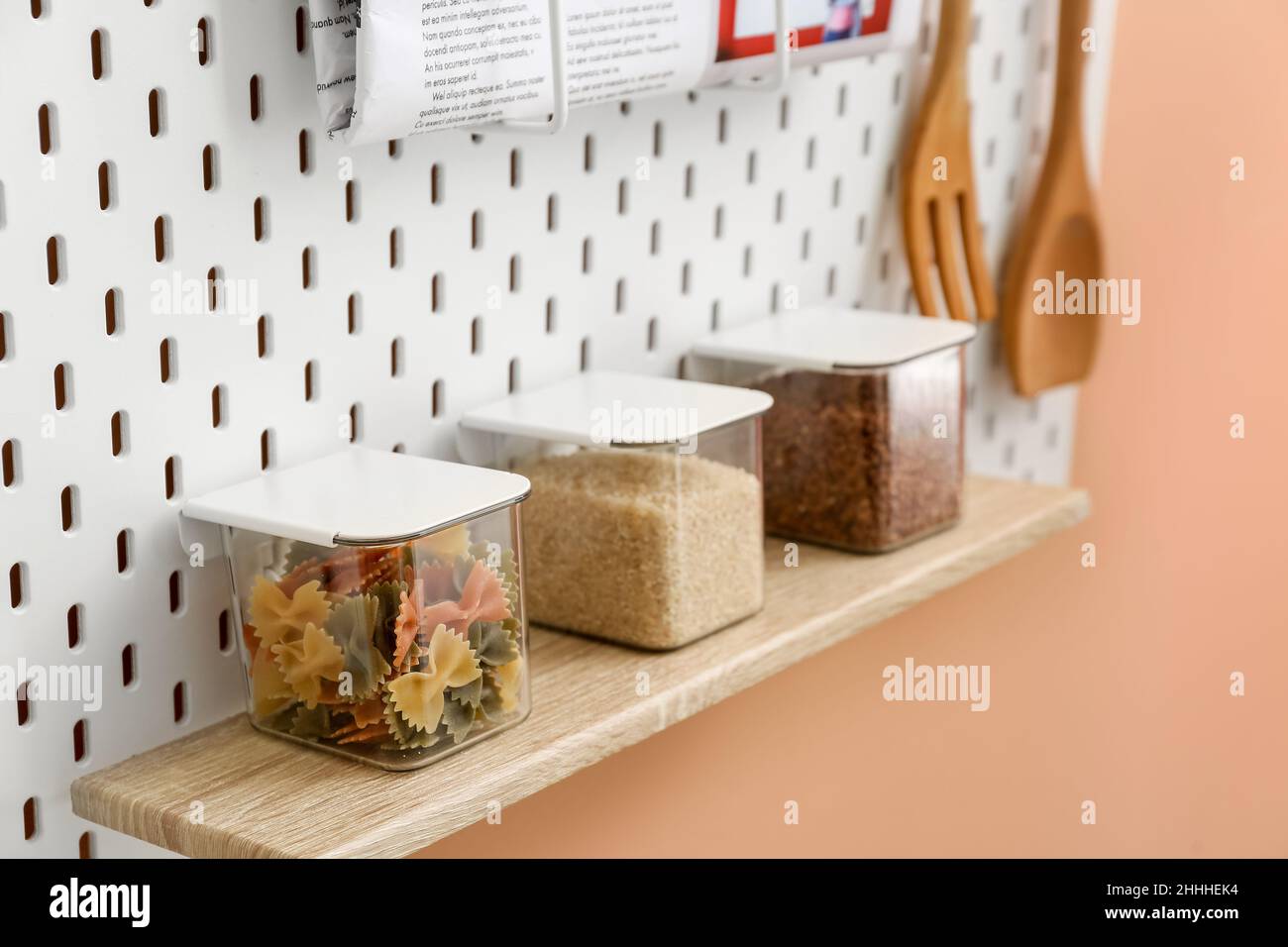 Jars with pasta and groats on pegboard, closeup Stock Photo Alamy