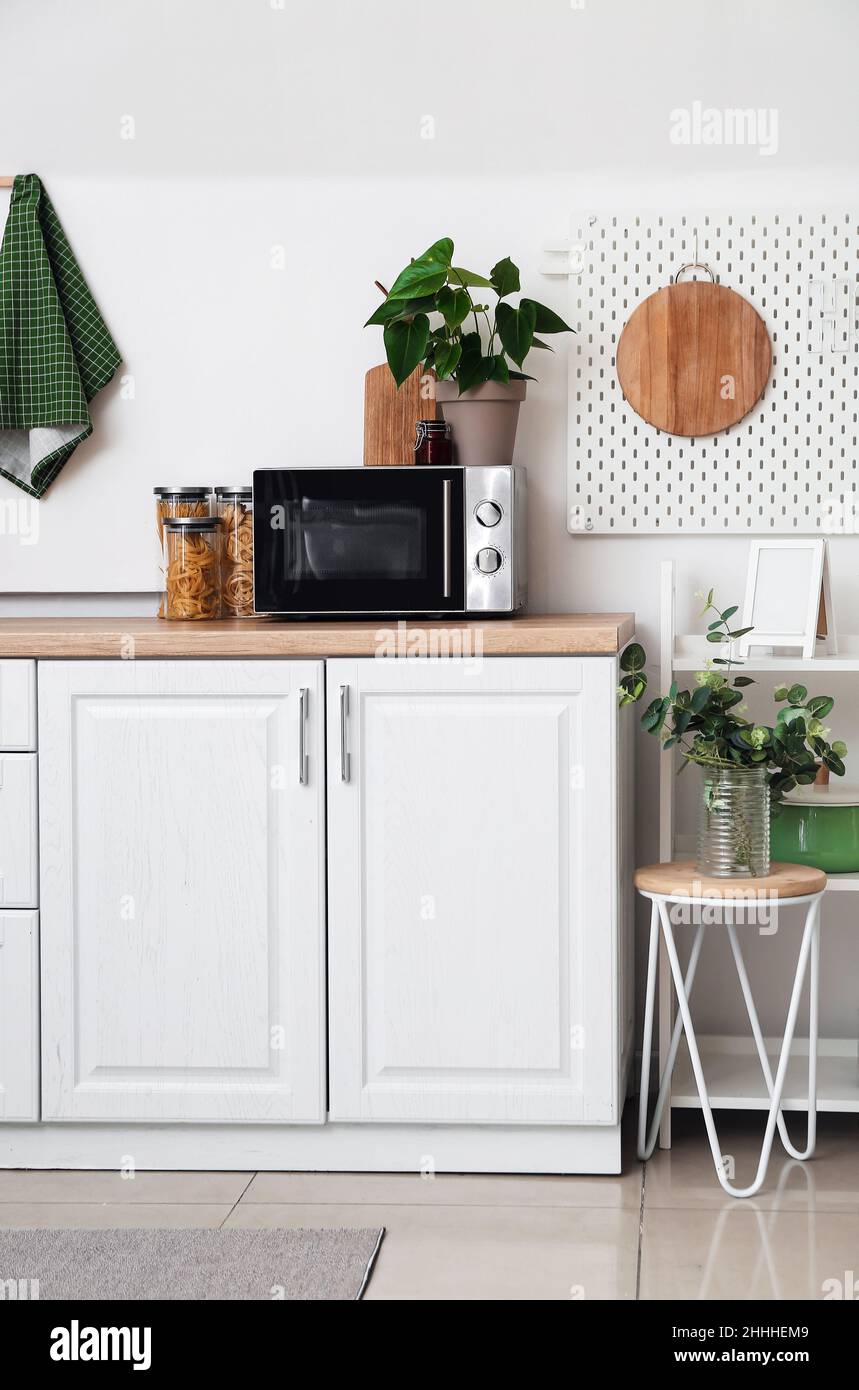 Modern microwave on counter near white wall in kitchen Stock Photo Alamy