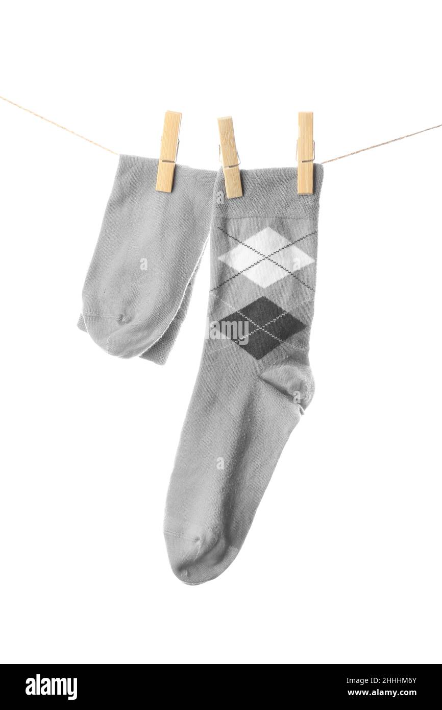 Male socks hanging on rope against white background Stock Photo - Alamy