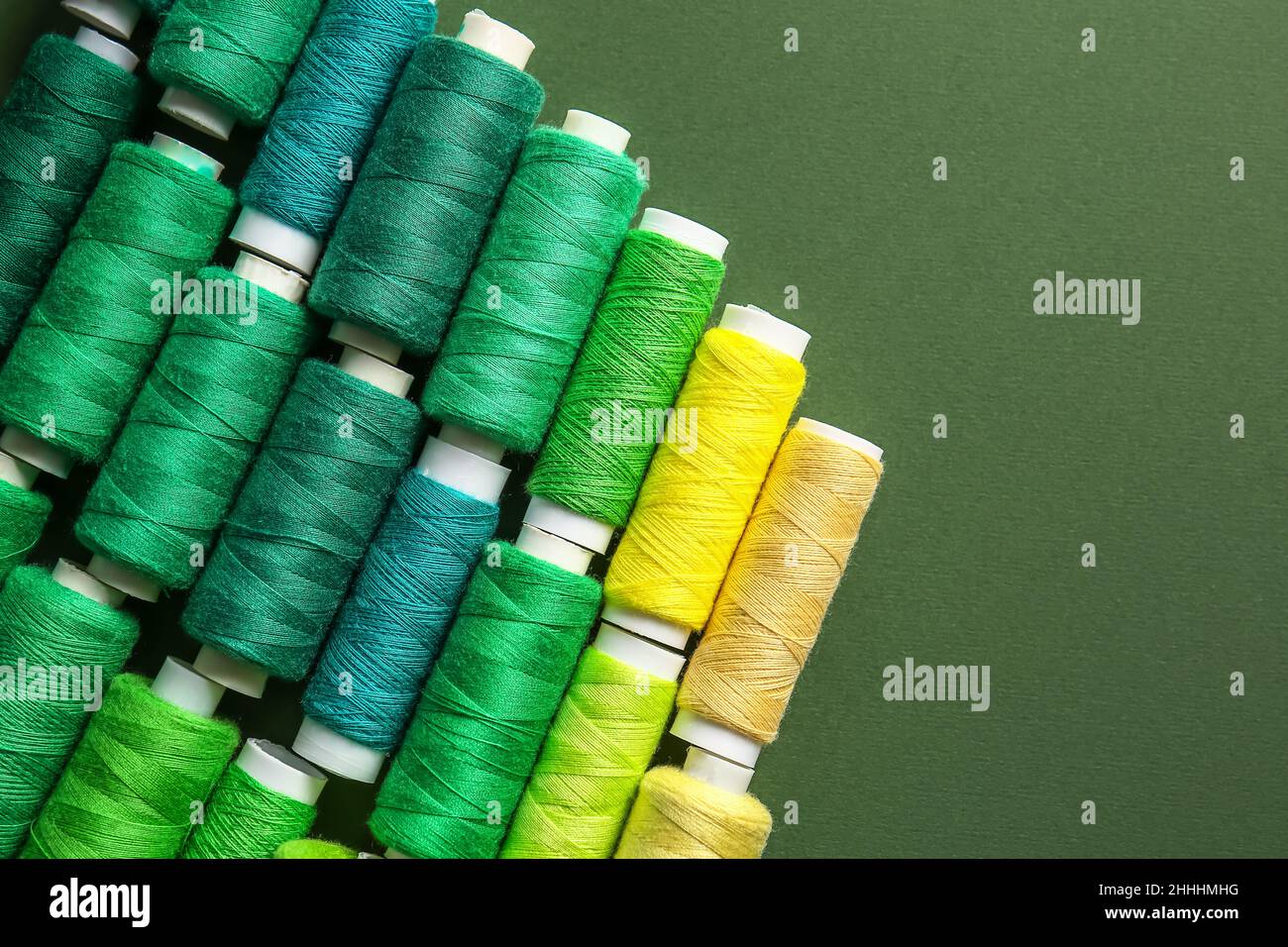 Spools with threads on green background Stock Photo