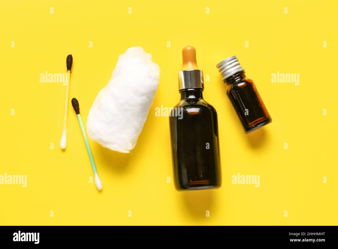 Medical cotton wool, swab and bottles with iodine on yellow background