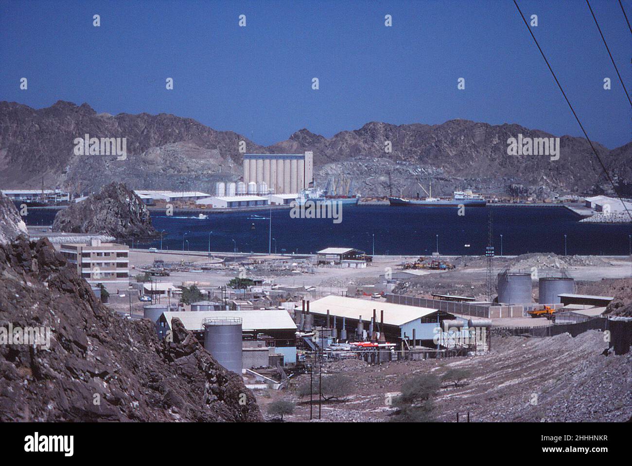 M/V Ibn Khallikan of United Arab Shipping Company (UASC), centre, in Port Sultan Qaboos (Mina Qaboos) Muscat, Oman, May 1978 Stock Photo