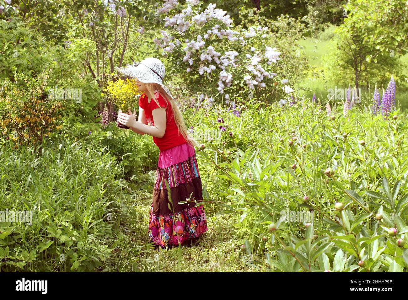Adorable girl in colorful dress in ethnic style with hat on her head ...