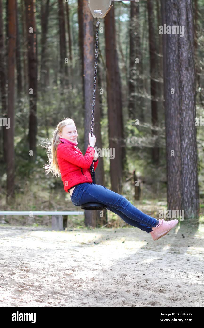 Happy blonde teenager girl jumping with bungee in park Stock Photo - Alamy