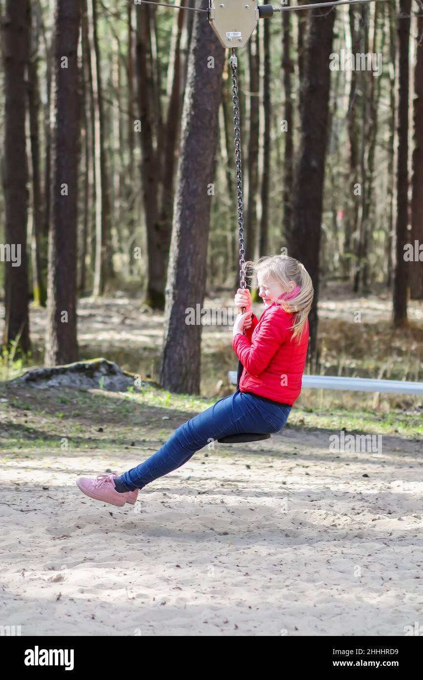 Happy blonde teenager girl jumping with bungee in park Stock Photo - Alamy
