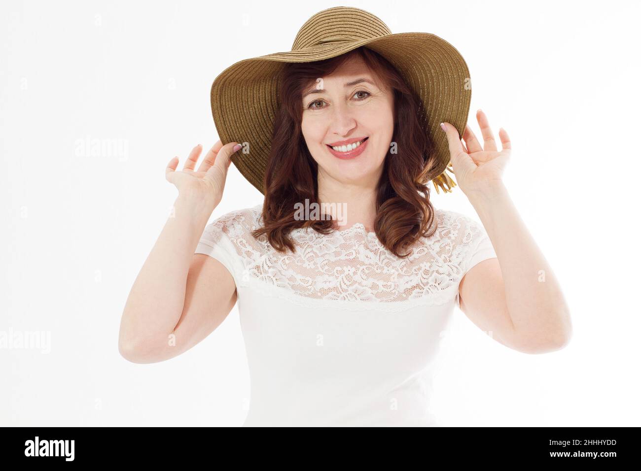 Happy middle age woman in summer hat isolated on white background with copy space. Summertime accessory face wrinkle skin protection. Happy menopause. Stock Photo
