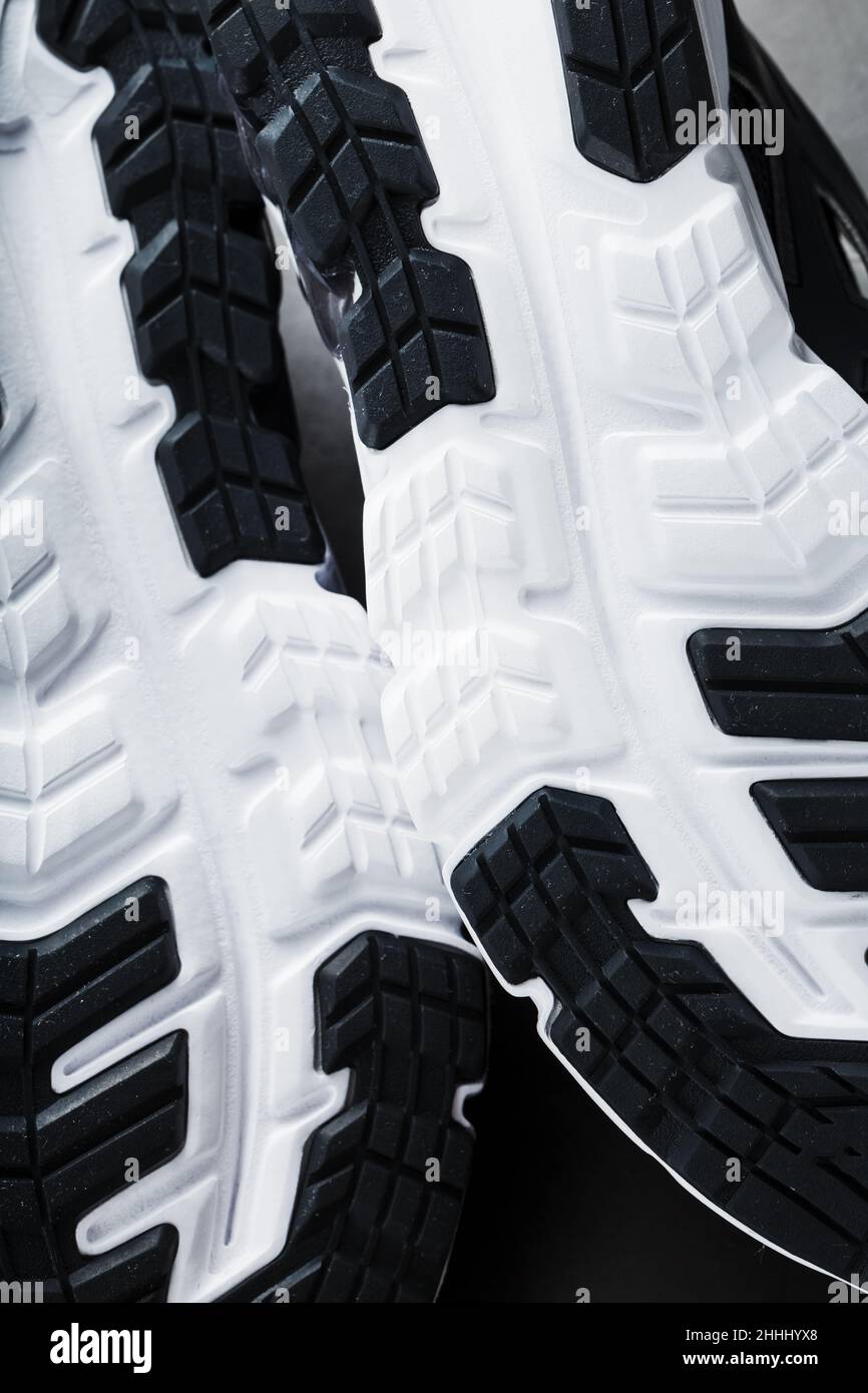 The black and white sole of trendy sports sneakers is a closeup in