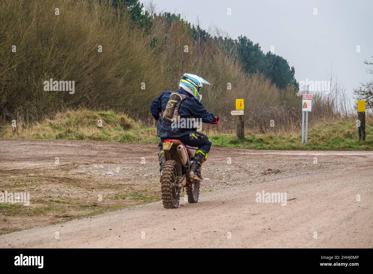 a motor cyclist (biker) riding their offroad motorbike along a stone