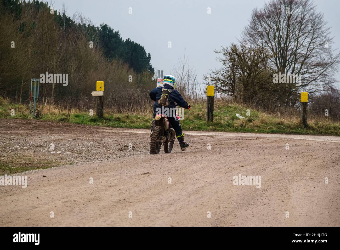 a motor cyclist (biker) riding their offroad motorbike along a stone