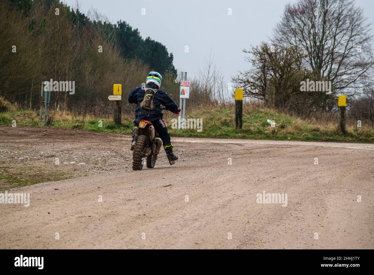 a motor cyclist (biker) riding their offroad motorbike along a stone
