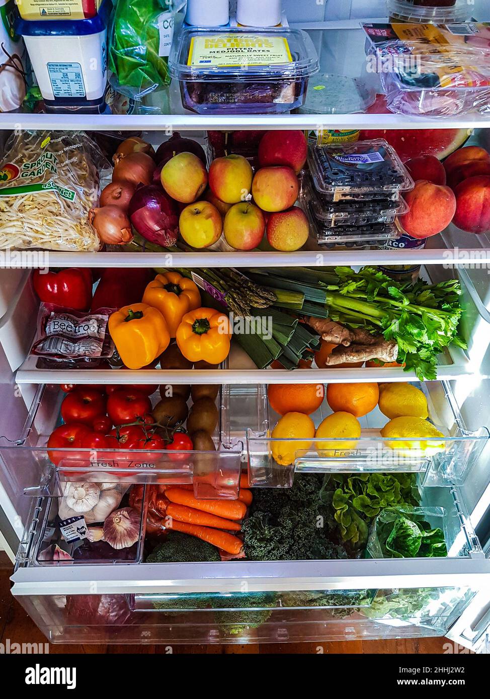 Fully stocked fridge of healthy food with various fruits and vegtables