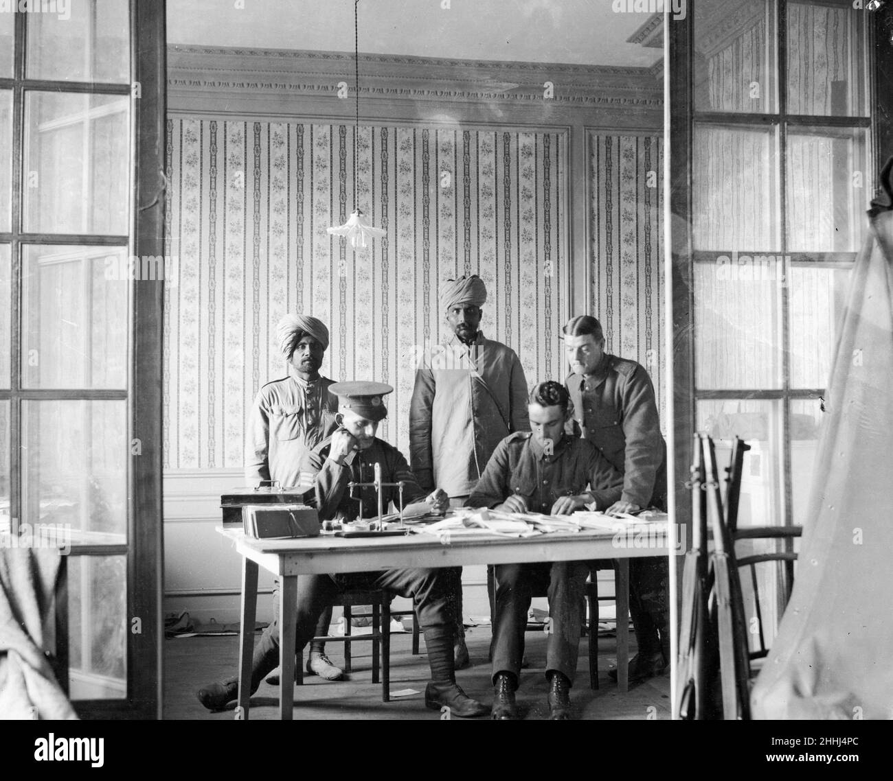 Indian and British soldiers at work censoring letters in a military post office in France Circa October 1914 Stock Photo