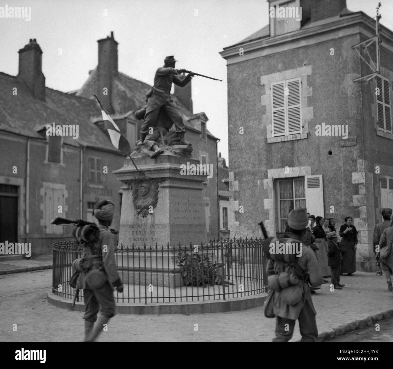 Troops from the 3rd Indian Division moving up to the front admire the statue of a 'French Soldier Firing' as they pass by. The statue marks the spot of an encounter between French and German soldiers in 1870. Circa October 1914 Stock Photo