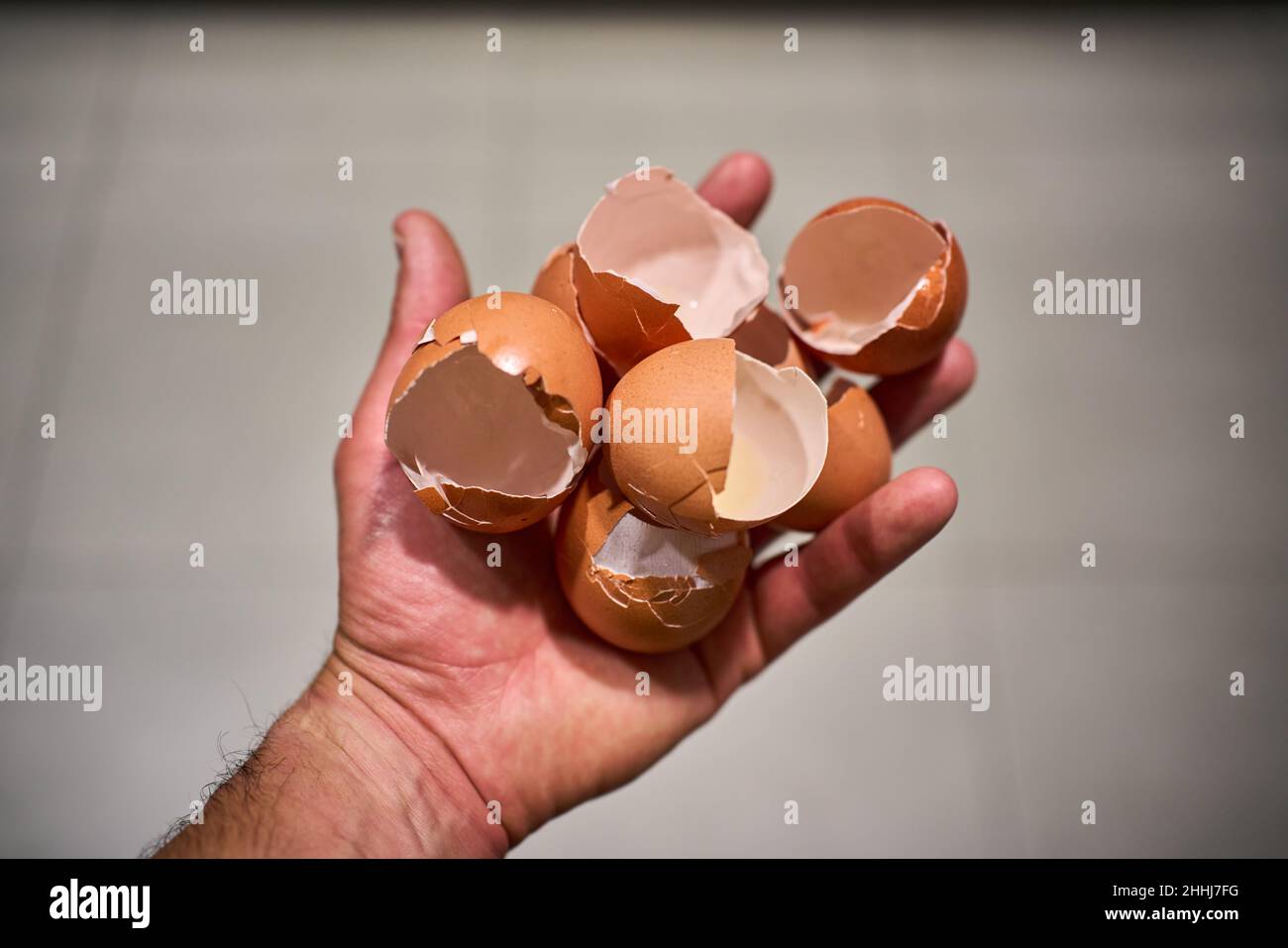 Hand with a handful of broken eggshells Stock Photo