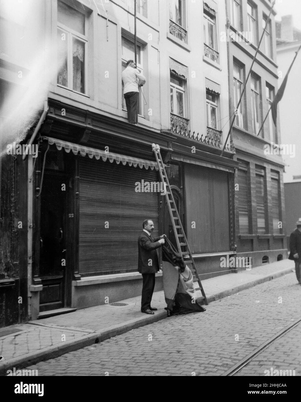 Shop owners taking down the Belgium flags before Louvain is occupied by the advancing German army. August 21st 1914 Stock Photo