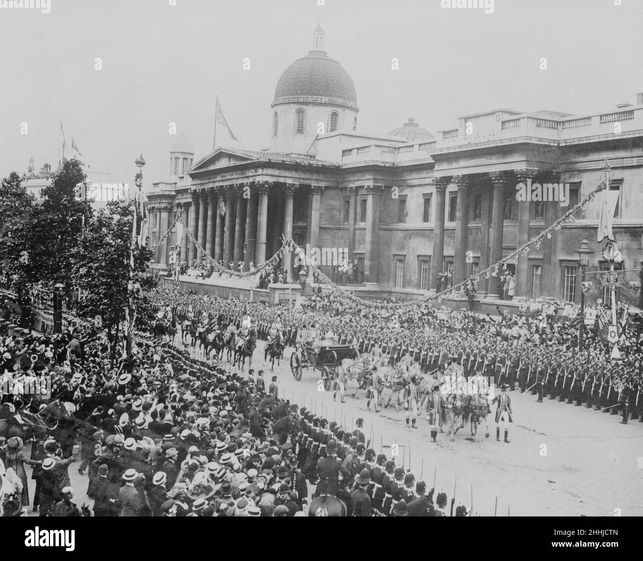 Coronation of King George V. Thousands of people cheer from the side of the road as the procession passes Trafalgar Square. 22nd June 1911. Stock Photo