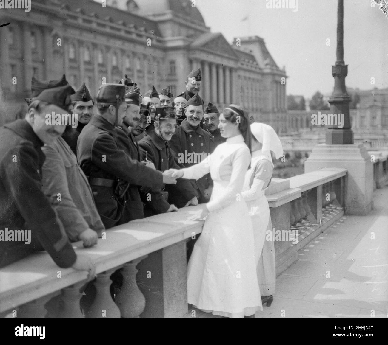 English nurses seen here meeting Belgian soldiers outside the Royal Palace  before leaving Brussels for the front to tend to the wounded. The inhabitants gave them a splendid welcome, and everyone commented on how kind and sympathetic they looked. Their soldiers, they felt would be in skilful hands. Every man who returns to the capitasl from Liege is regarded as a hero and is made to tell again and again the wonderful story of how the Germans were repulsed by a heroic little band of defenders. August 1914 Stock Photo