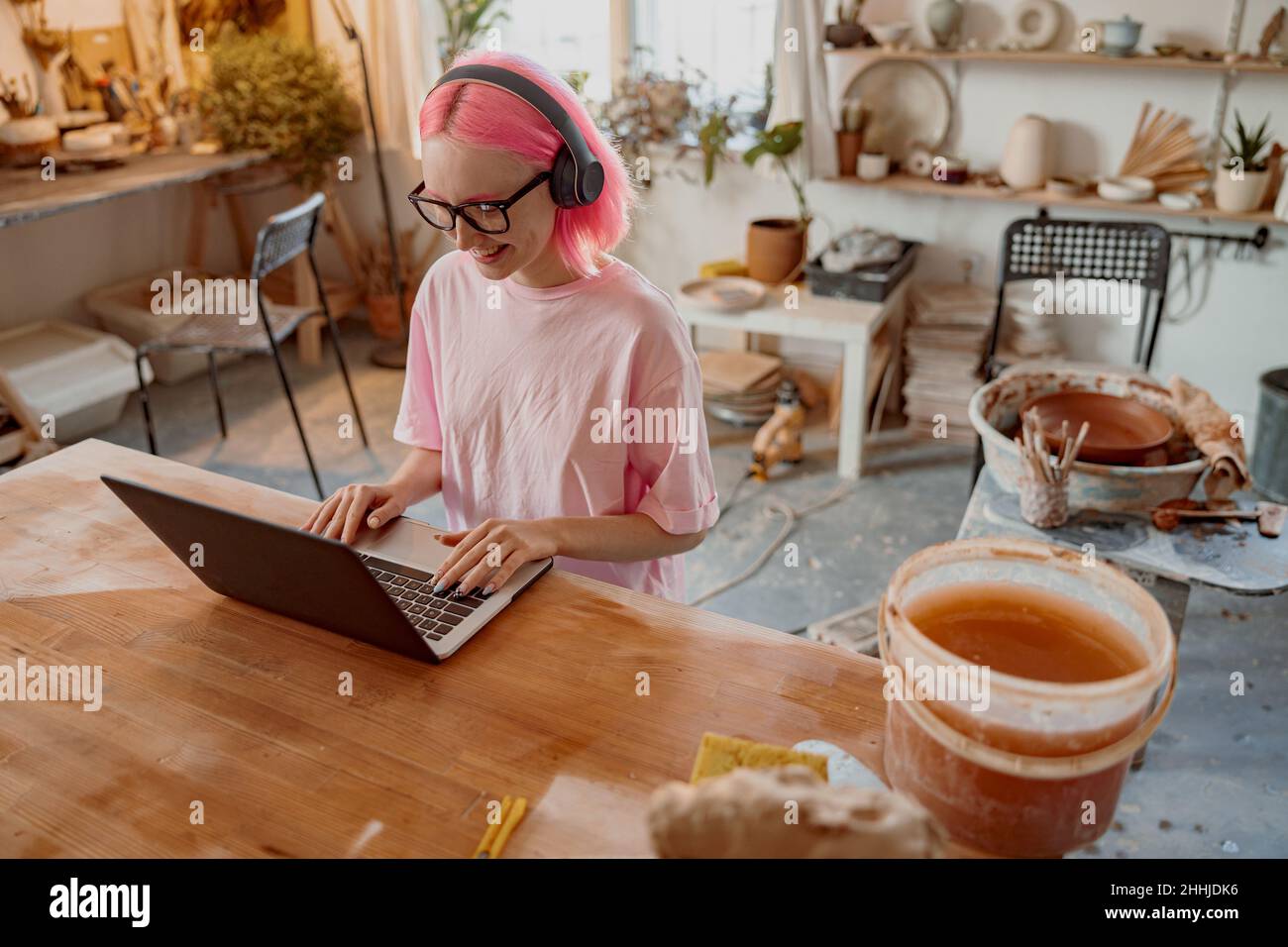 Woman potter using laptop in art studio Stock Photo