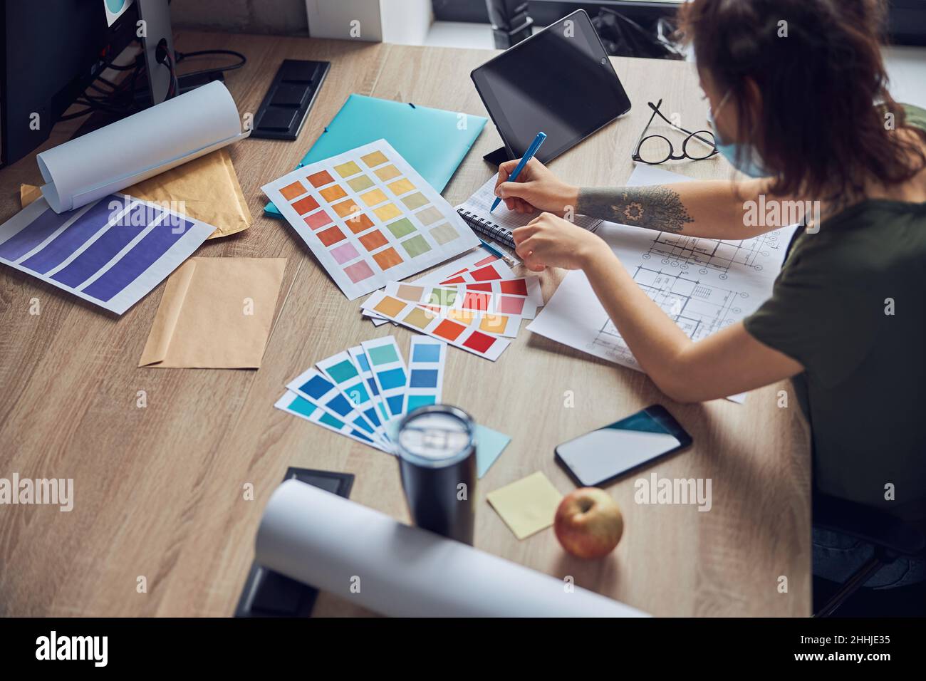 Working process of female interior designer making notes in her ...