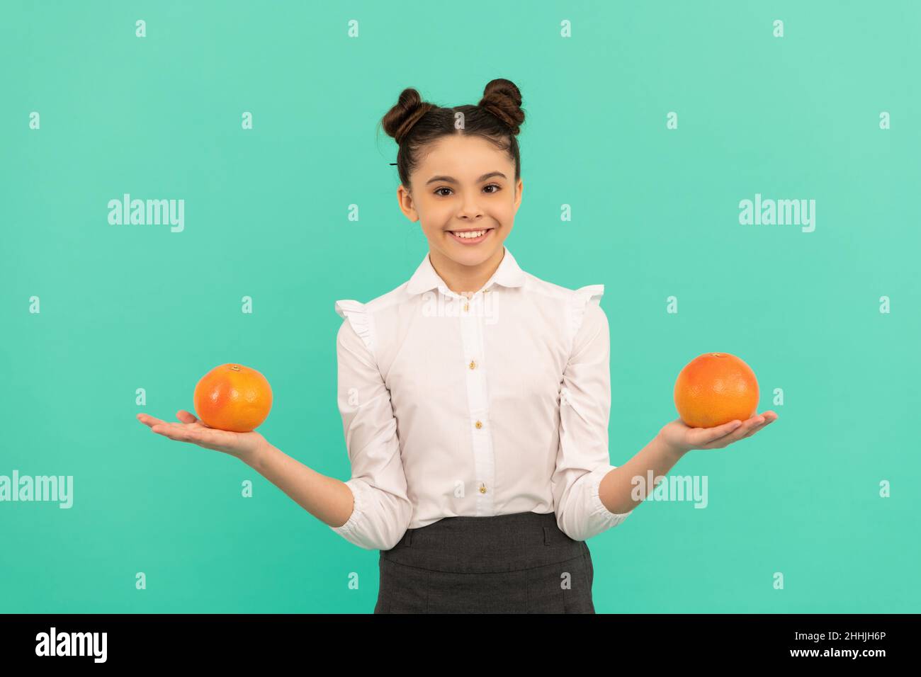 happy teen girl with grapefruit citrus fruit. vitamin and dieting. child eating healthy food. Stock Photo