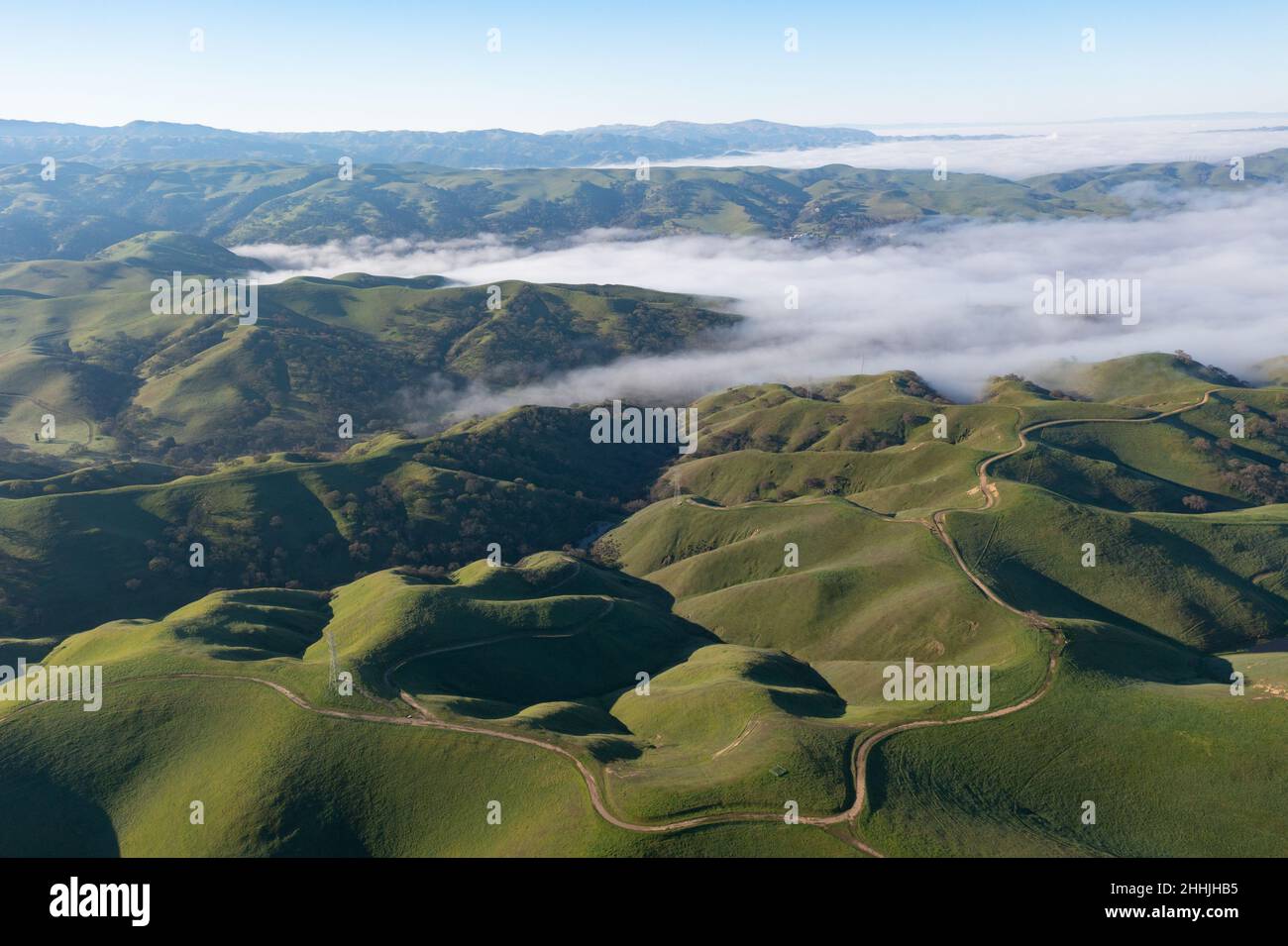 The marine layer seeps over the green, rolling hills and valleys of Livermore, Northern California, just east of San Francisco Bay. Stock Photo