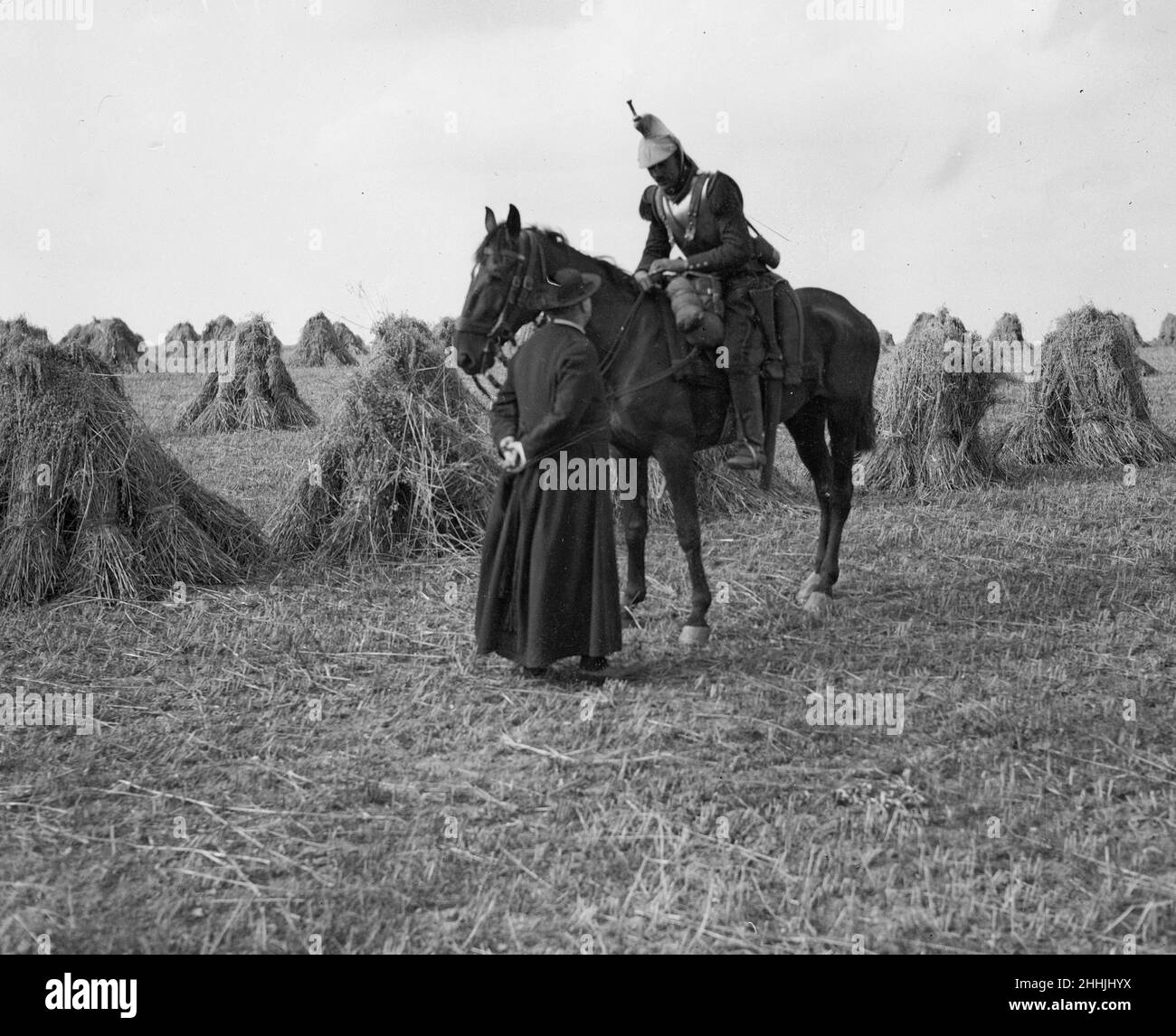 A priest talks to a French Cuirassiers in a corn field on the Belgium - France border. Circa August 1914 Stock Photo