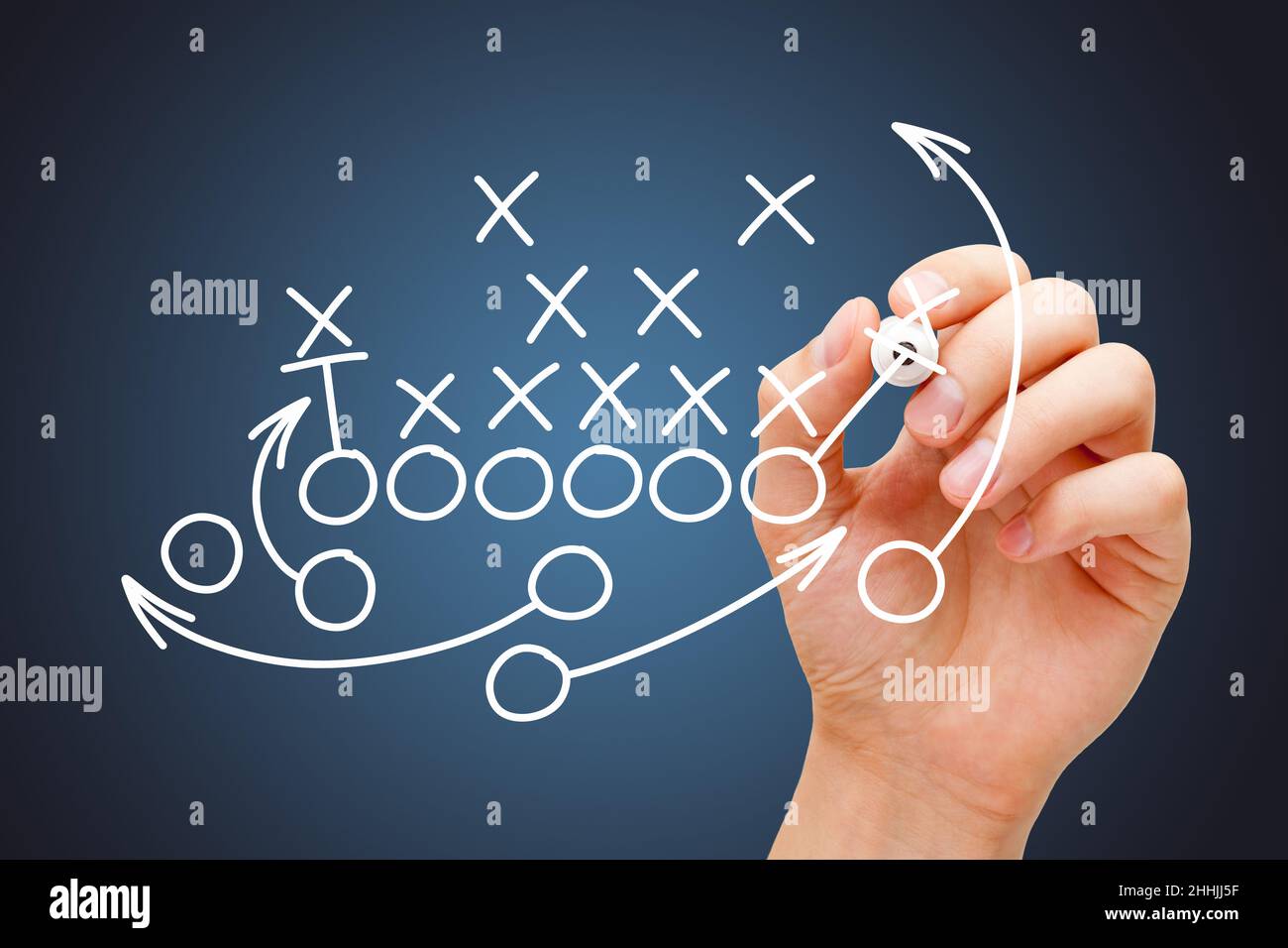 Coach drawing american football or rugby game playbook, strategy and tactics with white marker on blue background. Stock Photo