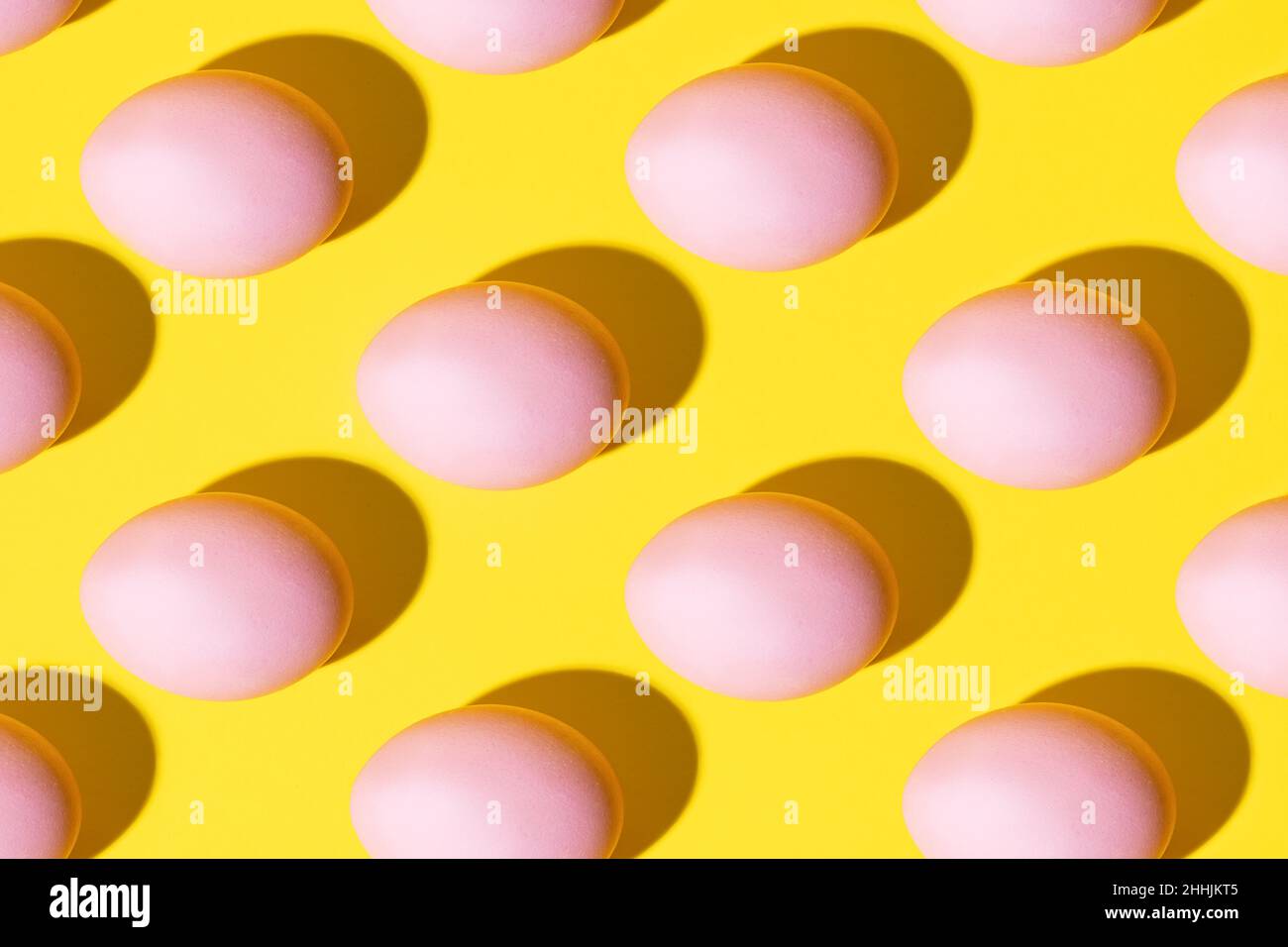 Pink eggs pattern on a yellow background Stock Photo
