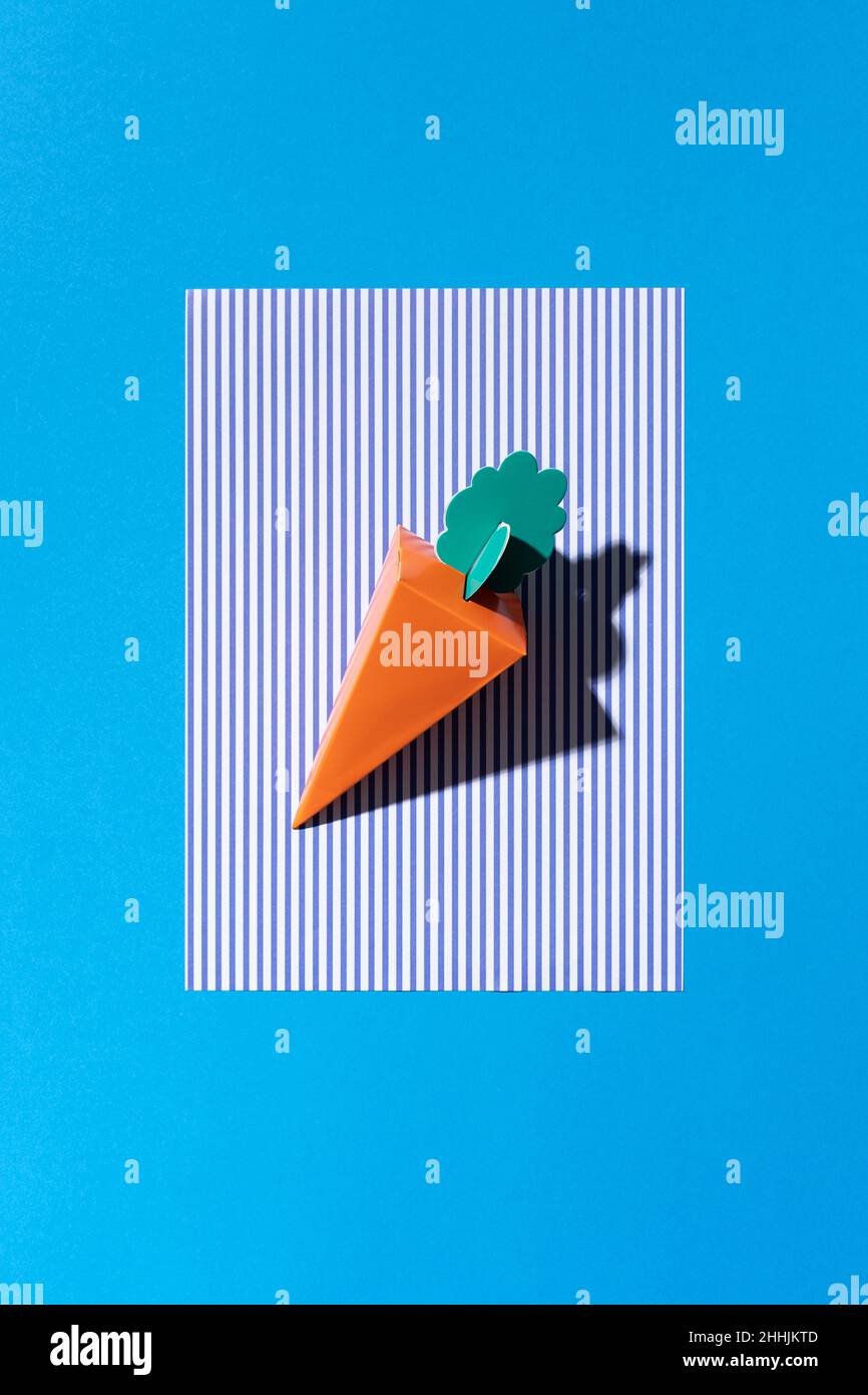 A cardboard carrot on a blue background Stock Photo