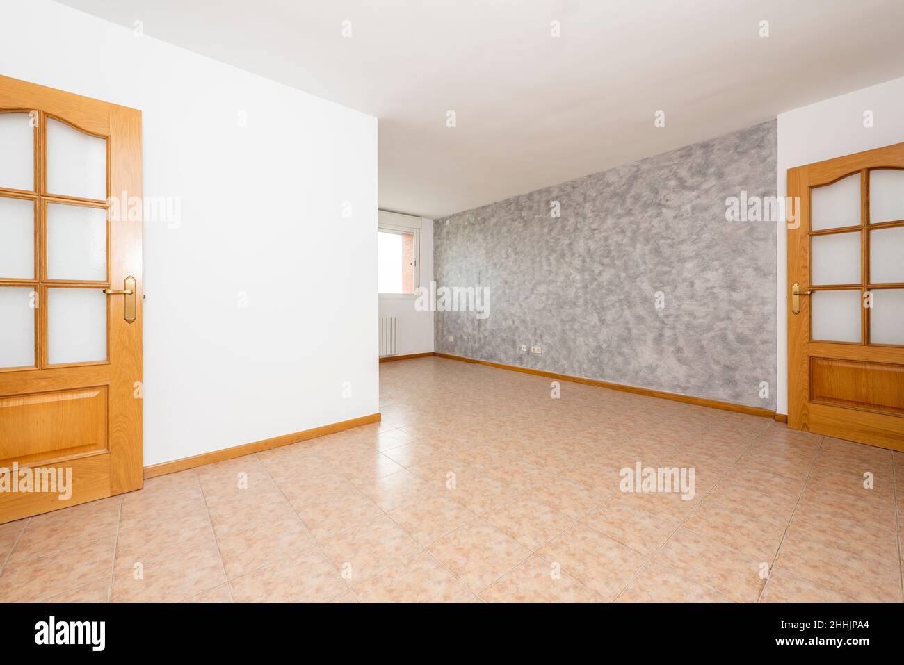 Empty living room with two-tone painted walls, stoneware floors, and oak woodwork Stock Photo