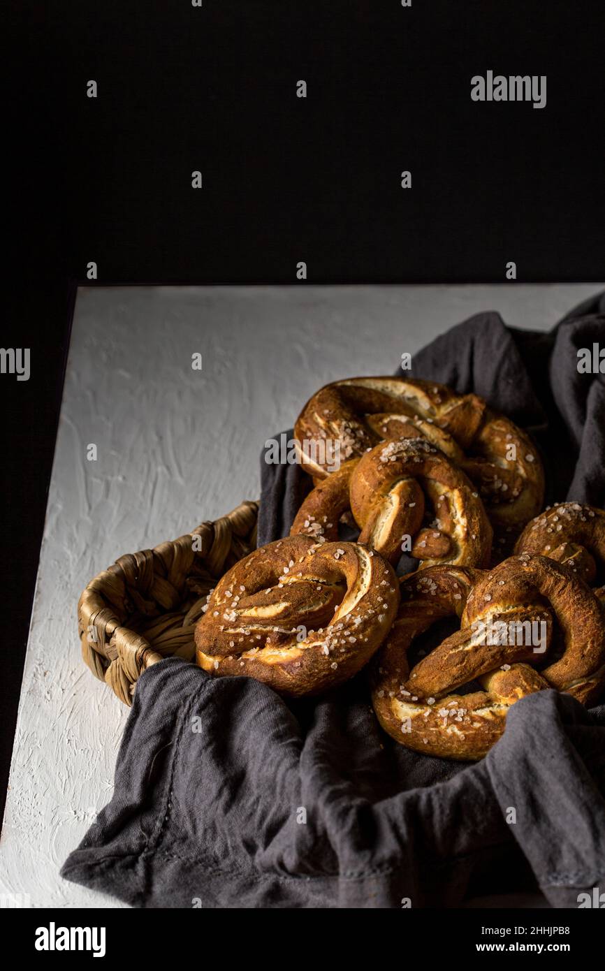 From above of appetizing homemade pretzel pastries on wicker tray with napkin placed on table Stock Photo