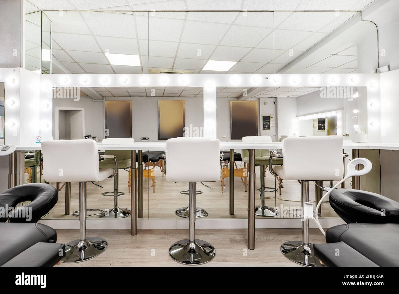 White chairs in front of a makeup mirror in a beauty salon Stock Photo