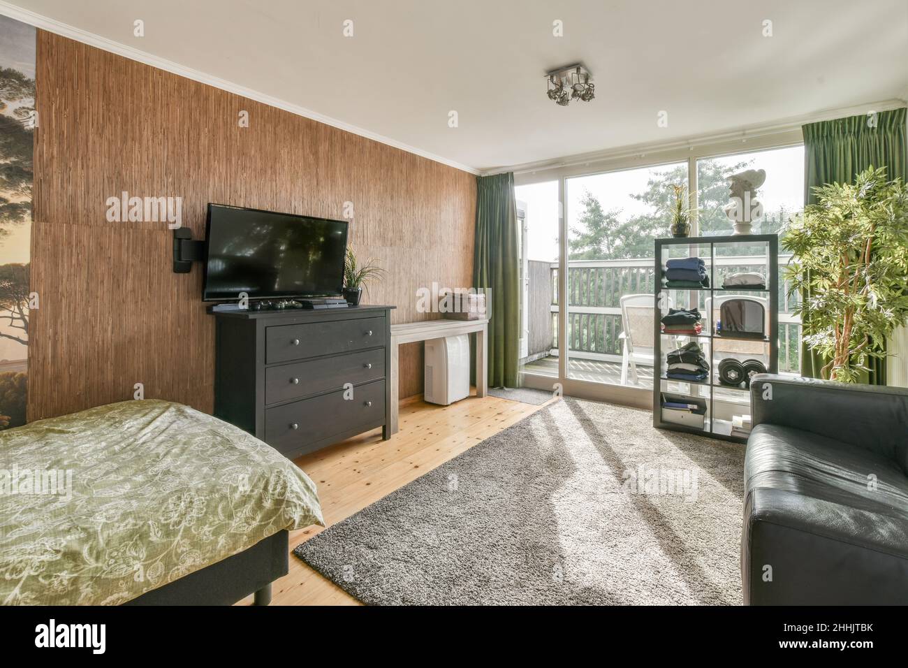 Modern TV hanging over chest of drawers in spacious teen bedroom with ...