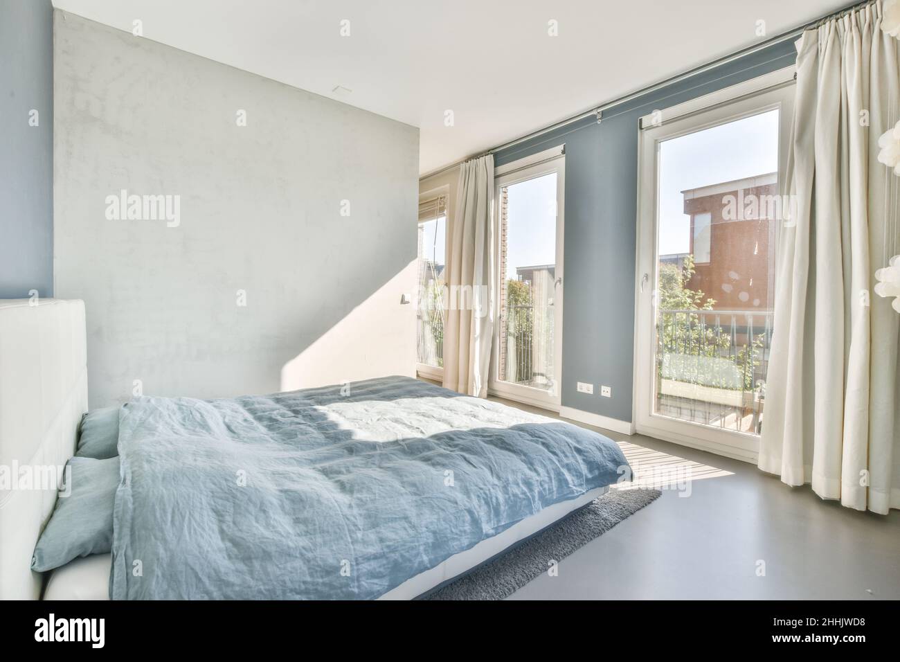 Interior of spacious bedroom with comfortable bed covered with soft