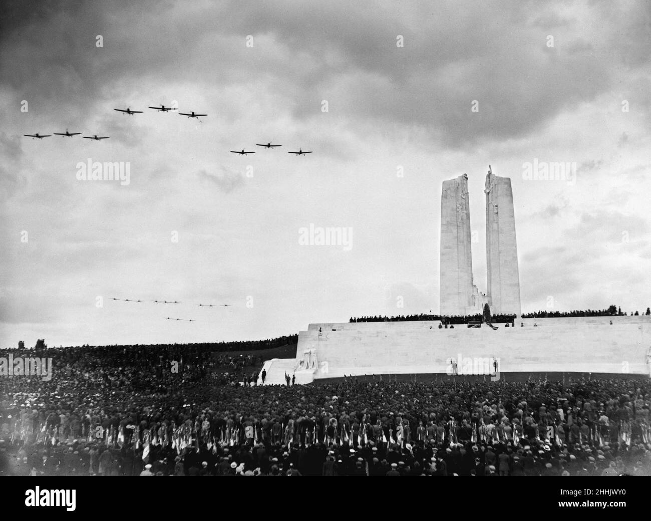 Aircraft  of the Royal Air Force and  French Air Force dip their wings in salute as they fly over the Canadian War Memorial at Vimy Ridge during the dedication ceremony.   The memorial was designed by Walter Seymour Allward. 26th July 1936 Stock Photo